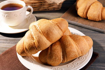 Delicious croissants on plate on table close-up
