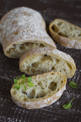 homemade bread ciabatta on dark brown wooden background