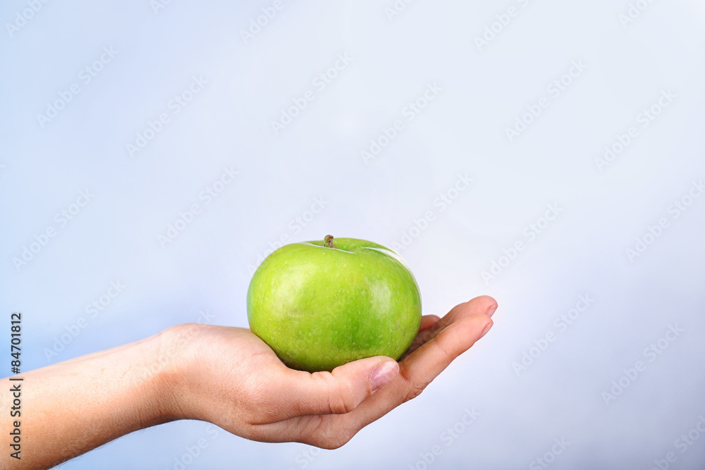 Wall mural female hand with apple on colorful background