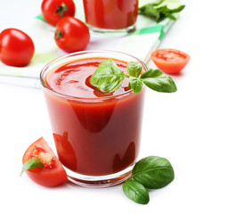 Glasses of fresh tomato juice on checkered napkin, isolated on white