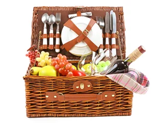 Papier Peint photo Pique-nique Wicker picnic basket with food, tableware and tablecloth isolated on white