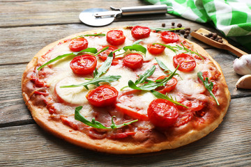 Delicious pizza with cheese and cherry tomatoes on wooden table, closeup