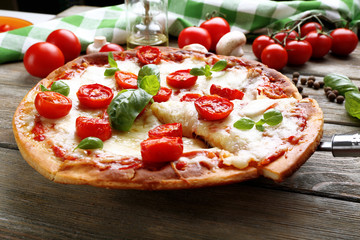 Delicious pizza with cheese and cherry tomatoes on wooden table, closeup
