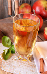Glass of apple juice on wooden background