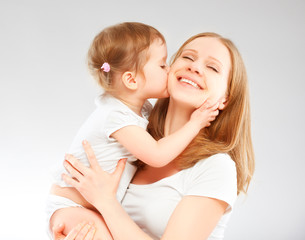 happy family mother and  baby daughter hugging and kissing