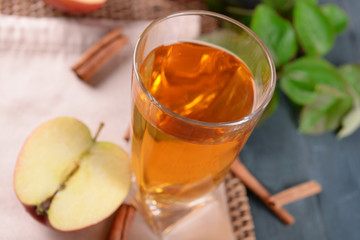 Glass of apple juice on wooden table, closeup