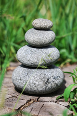 Obraz na płótnie Canvas Stack of spa stones over green grass background
