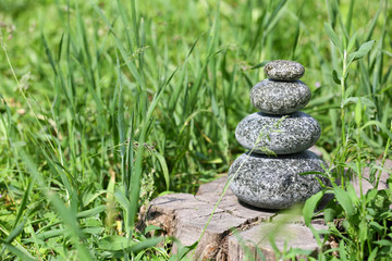 Stack of spa stones over green grass background