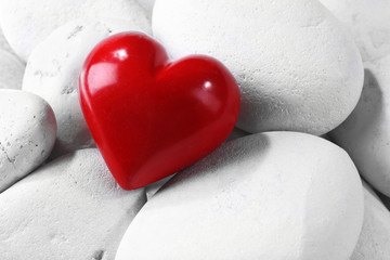 Obraz premium Red heard over pebbles background