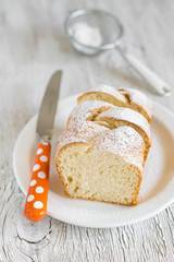 sweet brioche with sugar on a white plate on a light background