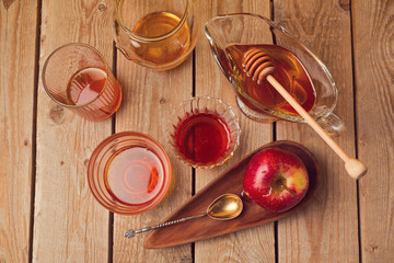 Honey jars and apple on wooden table. View from above