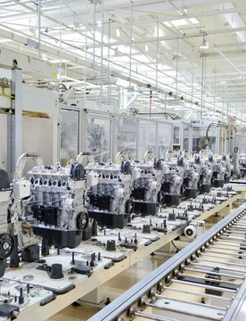 New manufactured car engines on automated production assembly line in a car factory. Manufacture of the engines for new car. New automotive engine on production line.