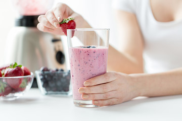 close up of woman with milkshake and strawberry