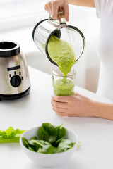 close up of woman with blender jar and green shake