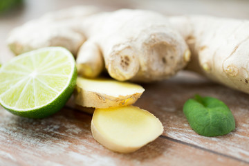 close up of ginger root and lime on wooden table