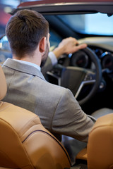 close up of man in cabriolet car at auto show