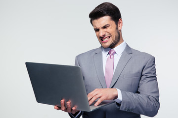 Angry businessman using laptop