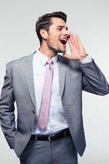 Businessman shouting over gray background