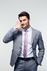 Handsome businessman shwoing call me gesture