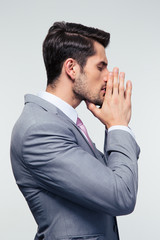 Businessman praying over gray background