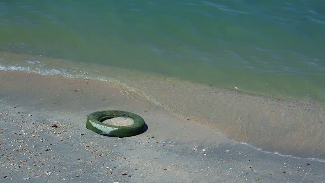 Car or truck tire left at sandy beach - Pattaya, Thailand