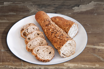 Plate with Pita Bread loafs and Baguette slices, on old Wooden Table.