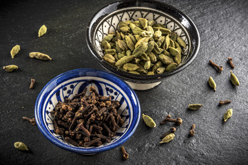 cardamom and cloves in ceramic bowls