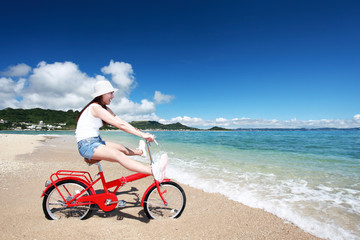 Fototapeta na wymiar 海辺でサイクリングを楽しむ女性