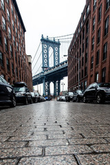 Manhattan Bridge towers in the background of Brooklyn street alley
