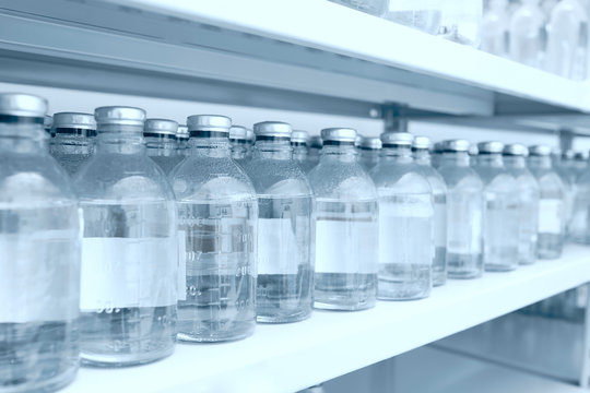Medicine bottles in row on storage shelf