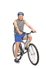 Naklejka premium Senior with a blue helmet posing on a bicycle