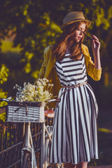 Fototapeta premium Young beautiful, elegantly dressed woman with bicycle. Beauty