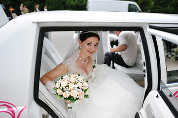 happy bride on wedding limousine