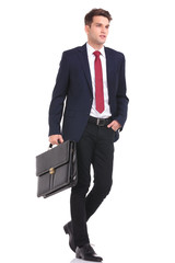 young business man walking with his hand in pocket