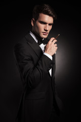 Young elegant man holding a cigarette in his hand.