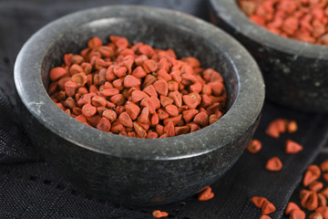 Annatto Seeds - Annatto (achiote) seeds in a black bowl.

