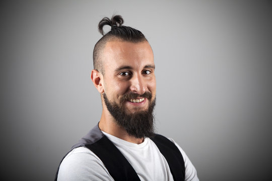 Hipster con pirri y chaleco sonriendo