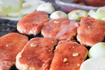 Raw pork steaks on grill