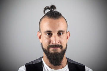 Primer plano de hipster con pirri, barba y chaleco