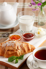 Croissant with jam, butter and tea