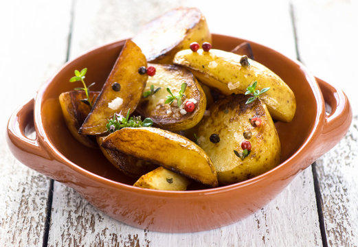     Delicious baked young potatoes on a wooden background 