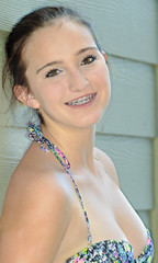 A pretty teenage girl in bikini smiling happily showing her braces.