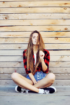 Trendy hipster girl sitting on the wooden porch