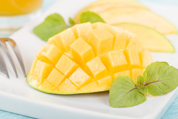 Mango - Hedgehog style cut ripe mango half on a white background.
