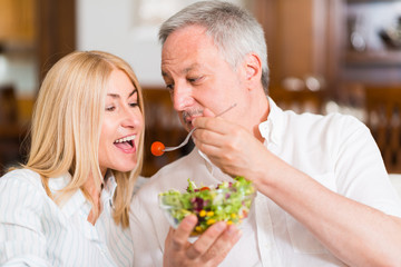 Obraz na płótnie Canvas Mature couple eating a salad