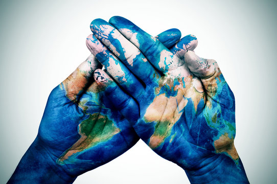 man hands patterned with a world map (furnished by NASA)