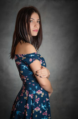 Happy beautiful woman in sundress on grey background.