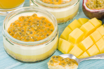 Mango & Passion Fruit Cheesecake - Individual potted dessert made with mango and passion fruit whipped cream and a biscuit base, topped with passion fruit pulp.
