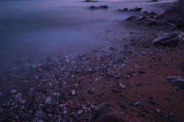 Tranquil seascape on rocky beach at twilight