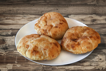 Plate with Pita Bread loafs and Baguette slices, on old Wood.